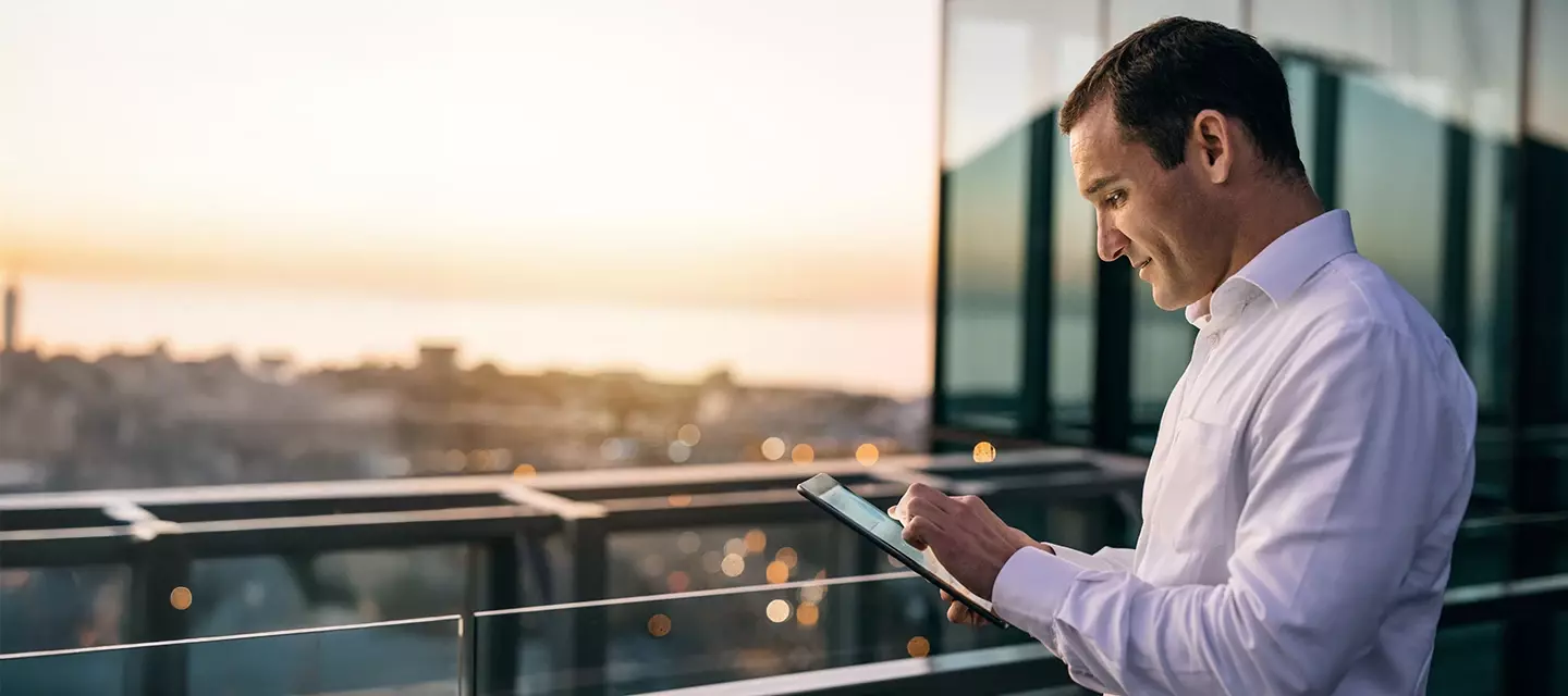 A man looking at a tablet high over a city panorama A man looking at a tablet high over a city panorama
